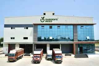 Garden's Need manufacturing facility building with company trucks, Khekra